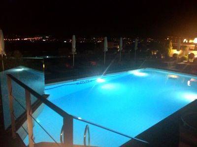 Novotel Atenas - Piscina no terraço iluminada à noite