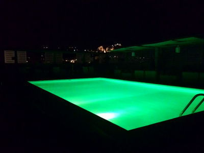 雅典丽笙公园酒店 - 在晚上以绿色照亮的屋顶游泳池