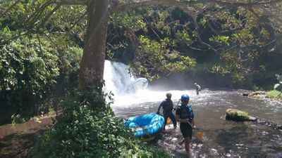Bali White Water Rafting - Guide che prendono la zattera sotto a cascata