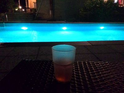 美居杜塞尔多夫诺伊斯酒店 - 在淡蓝色照亮的室外游泳池的酒杯